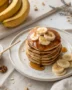 A stack of golden banana pancakes drizzled with maple syrup, showcasing the perfect banana pancake recipe.