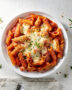 A golden-brown pan of baked ziti fresh from the oven, with stretchy melted cheese and rich tomato sauce.