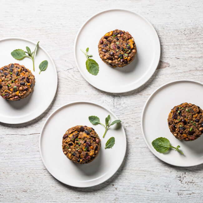 Two perfectly seared bean burgers with vibrant toppings on a toasted bun, ready to be enjoyed.