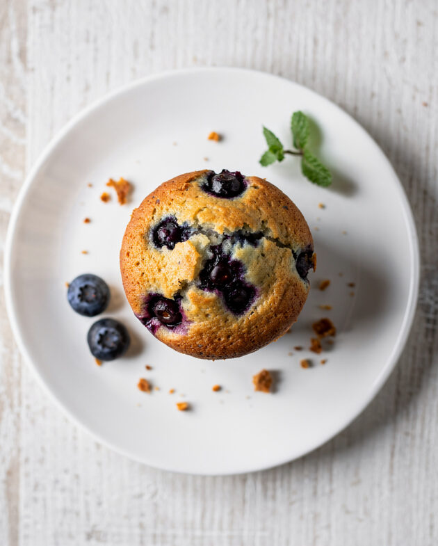 A batch of freshly baked blueberry muffins from the best blueberry muffin recipe, with a golden crumb topping.