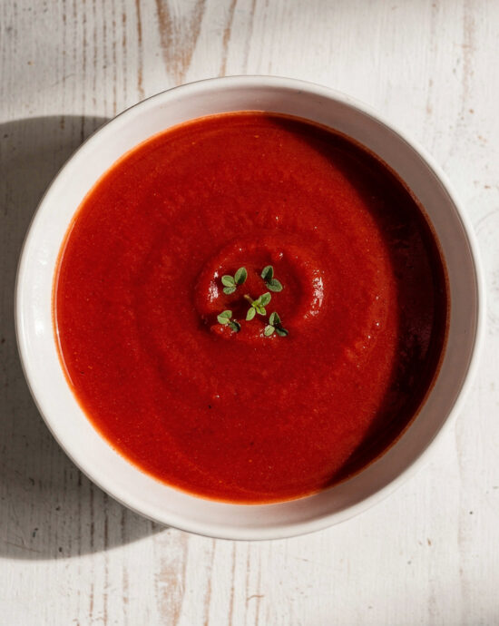 A velvety bowl of the best tomato soup brand, topped with fresh basil and a swirl of cream.