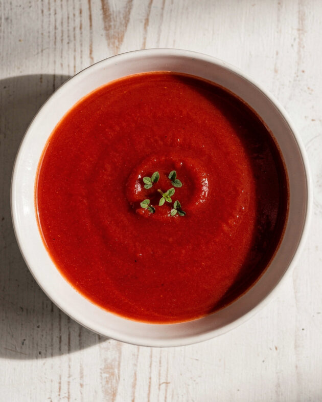 A velvety bowl of the best tomato soup brand, topped with fresh basil and a swirl of cream.