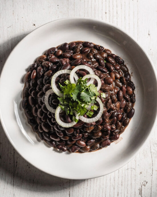 A steaming bowl of hearty black beans brazilian stew served over fluffy white rice.
