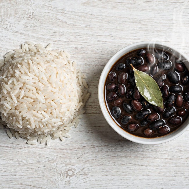 A rustic bowl of creamy black beans served alongside fluffy white rice, showcasing the classic comfort of brazil beans and rice.