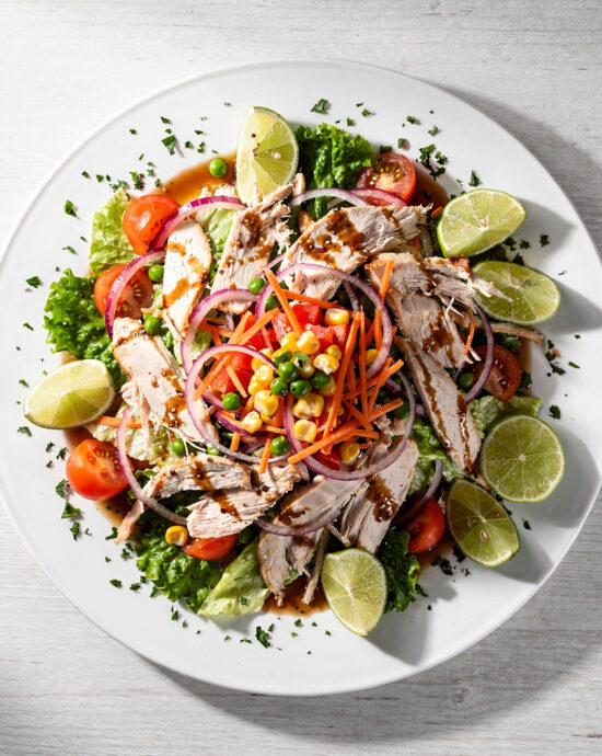 A colorful and crunchy Brazilian chicken salad (salpicão) served on a white platter.