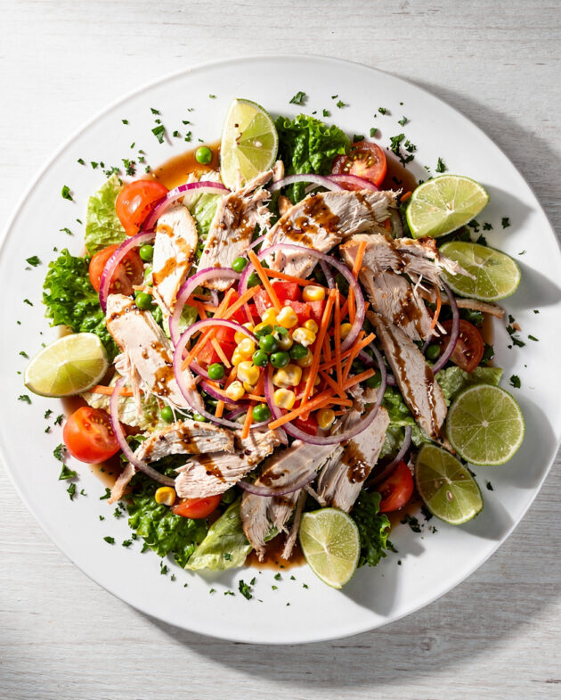 A colorful and crunchy Brazilian chicken salad (salpicão) served on a white platter.