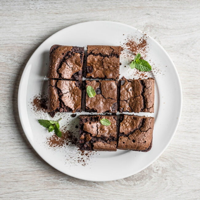 A beautifully baked brownie cake recipe presented on a rustic wooden table.