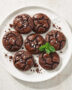 A stack of perfect brownie cookies with crackly tops and gooey centers, ready to be devoured.