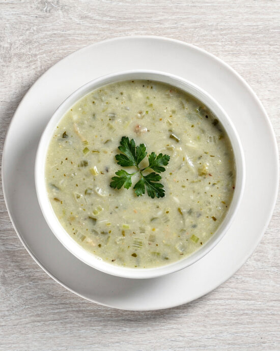 A creamy bowl of homemade-style soup made with Campbell's cream of celery soup, garnished with fresh herbs.