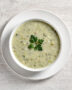 A creamy bowl of homemade-style soup made with Campbell's cream of celery soup, garnished with fresh herbs.