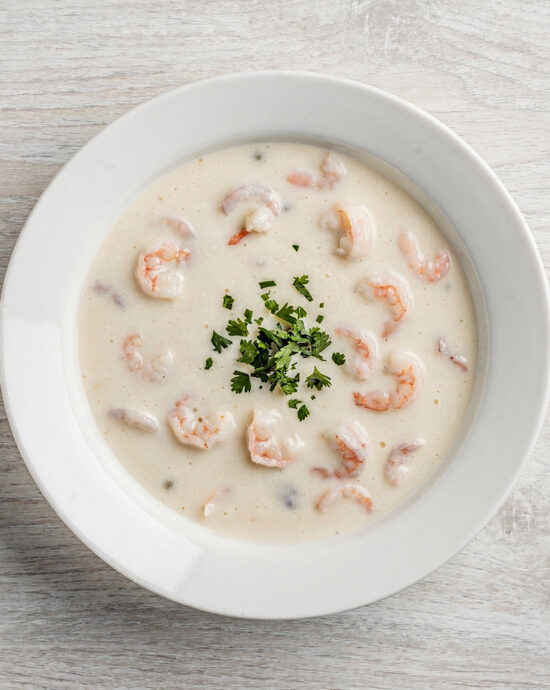 A creamy, inviting bowl of campbell's cream of shrimp soup garnished with fresh parsley, perfect for a cozy meal.