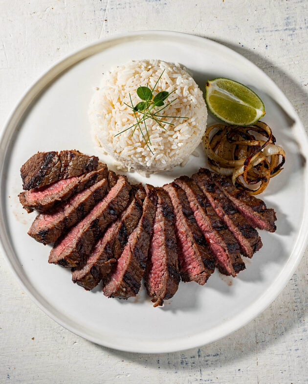 Juicy, perfectly grilled carne asada recipe slices resting on a wooden cutting board, ready to be served.