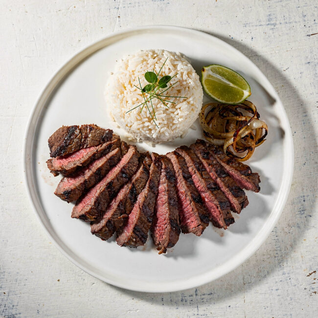 Juicy, perfectly grilled carne asada recipe slices resting on a wooden cutting board, ready to be served.