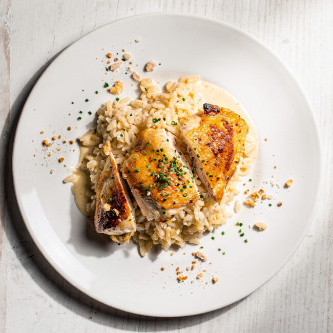 A golden-brown chicken and rice casserole fresh from the oven, steaming invitingly on a rustic table.