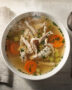 A steaming bowl of homemade chicken soup with carrots, celery, and tender chicken, garnished with fresh dill.