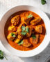 A beautifully plated bowl of homemade chicken tikka masala, featuring tender chicken in a rich, creamy tomato sauce, garnished with fresh cilantro.