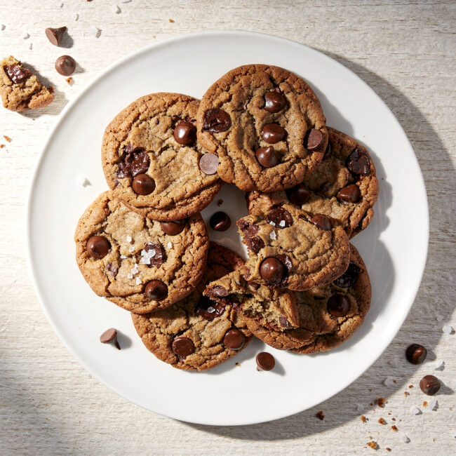 A stack of warm, chewy chocolate chip cookies from our perfect chocolate chip recipe, ready to be enjoyed.