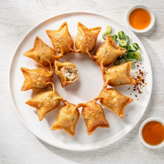 A golden platter of freshly fried crab rangoon recipe, showcasing their crisp texture and creamy filling.