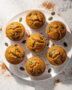 A batch of golden brown easy cake mix pumpkin muffins cooling on a wire rack.