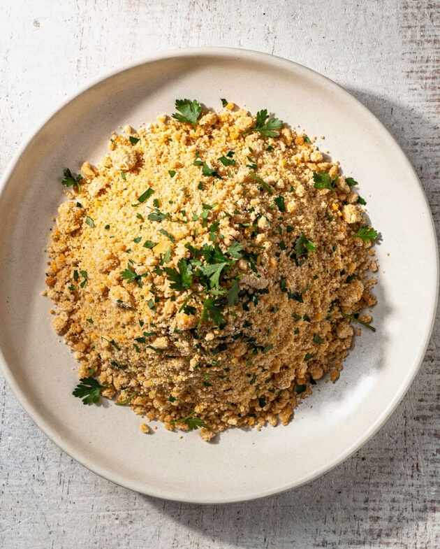 A beautifully toasted and textured farofa recipe, served in a rustic wooden bowl, ready to be sprinkled over your favorite dishes.