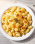 A creamy, golden-brown baked gluten free mac and cheese in a cast iron skillet, ready to serve.