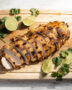 A beautifully plated grilled chicken breast recipe with a golden glaze on a rustic wooden board.