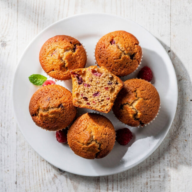 A rustic, textural shot of the best homemade muffin recipe, featuring golden-brown domes dusted with cinnamon sugar.