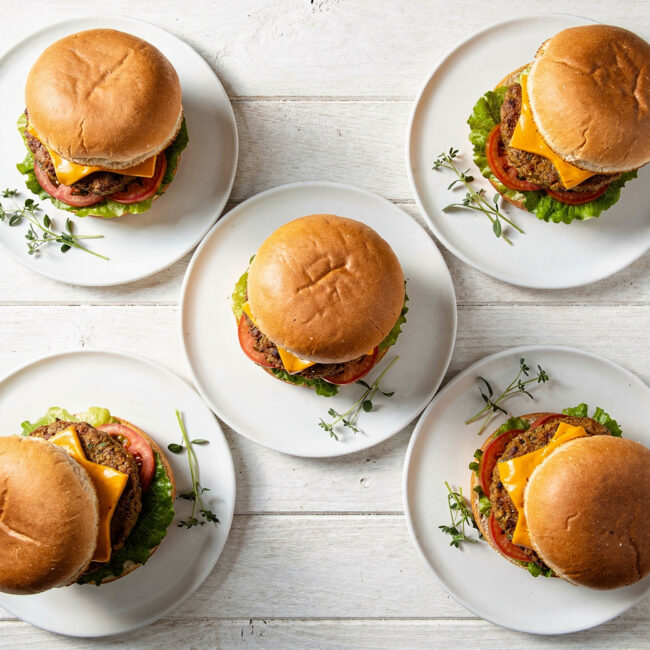 A juicy, perfectly cooked impossible burger recipe sits on a wooden board, ready to be devoured.