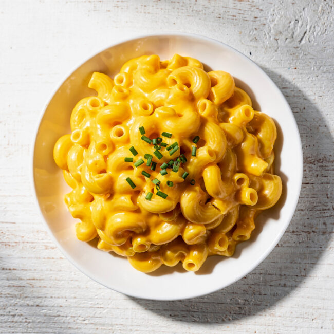 A creamy bowl of instant pot mac and cheese topped with fresh chives, ready to be enjoyed.