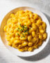 A creamy bowl of instant pot mac and cheese topped with fresh chives, ready to be enjoyed.