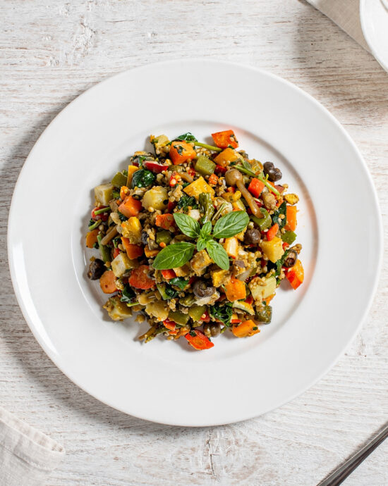 A creamy bowl of potato and leek soup made with knorr vegetable recipe mix, garnished with chives, on a rustic wooden table.