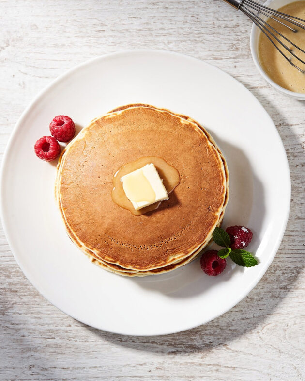 A perfectly stacked plate of fluffy golden pancakes made from this easy pancake mix recipe, drizzled with maple syrup.