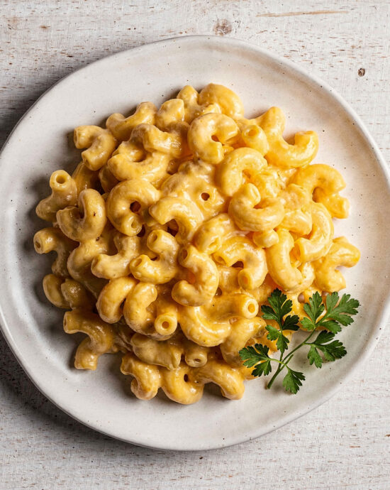 A creamy, golden bowl of our homemade panera mac and cheese recipe, garnished with fresh parsley.