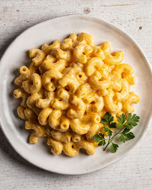 A creamy, golden bowl of our homemade panera mac and cheese recipe, garnished with fresh parsley.