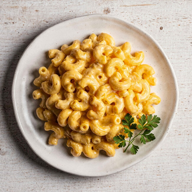 A creamy, golden bowl of our homemade panera mac and cheese recipe, garnished with fresh parsley.