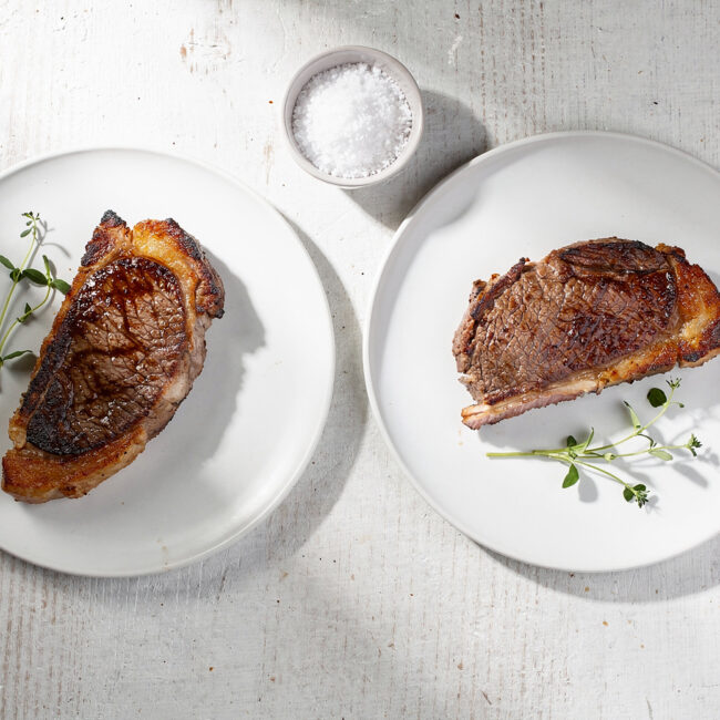 Perfectly grilled picanha steaks resting on a wooden board, showcasing a deep caramelized crust and juicy interior.