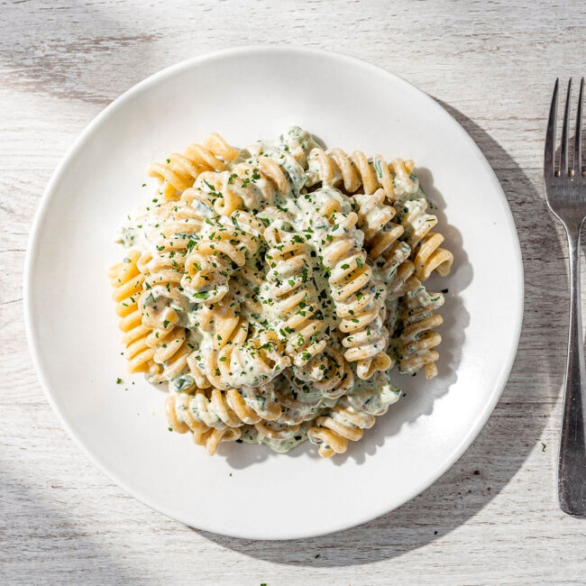 A creamy, perfectly sauced ranch pasta recipe served in a rustic white bowl, garnished with fresh herbs.