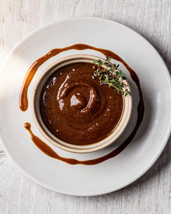 A vibrant green skirt steak sauce drizzled over perfectly grilled steak on a rustic wooden board.