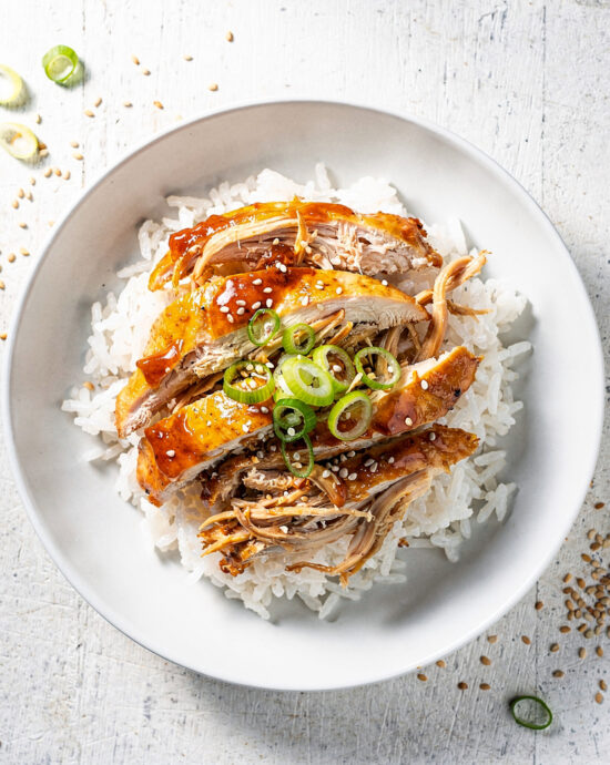 Tender slow cooker chicken breast recipes with honey garlic sauce served over fluffy rice.