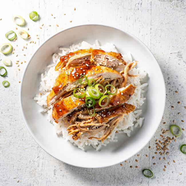 Tender slow cooker chicken breast recipes with honey garlic sauce served over fluffy rice.