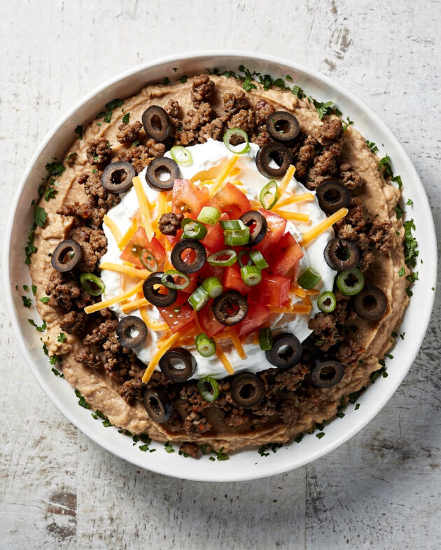 A colorful and inviting taco dip served in a rustic dish, ready for scooping.