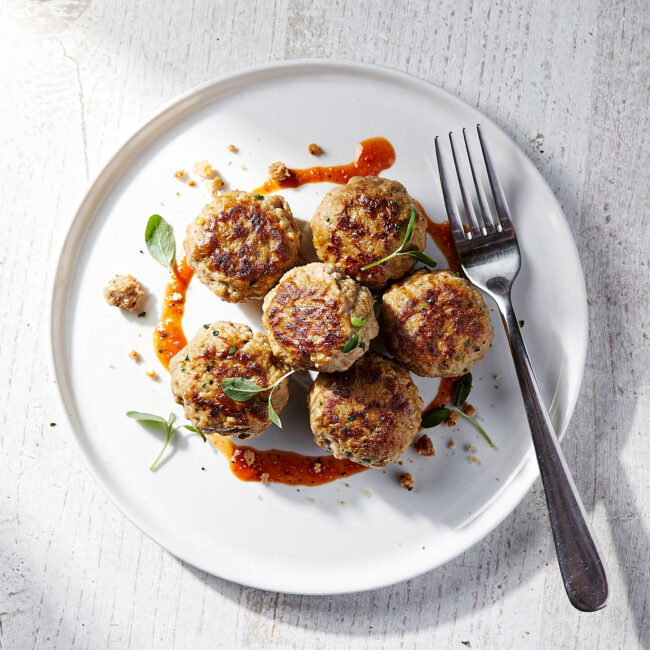 A beautifully plated turkey meatball recipe with a vibrant herby lemon-garlic sauce.
