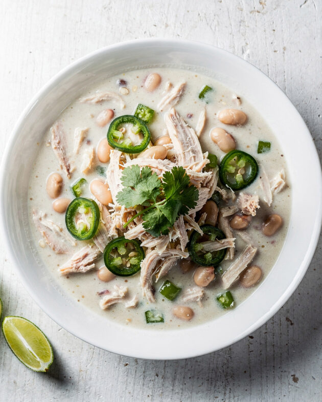 A creamy and comforting bowl of white chicken chili recipe, garnished with lime and cilantro.