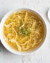 A perfectly executed egg drop soup recipe, featuring silky egg ribbons in a clear, savory broth, garnished with scallions.